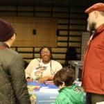 Two people and a child speak with an SPS staff member at the Admissions Fair